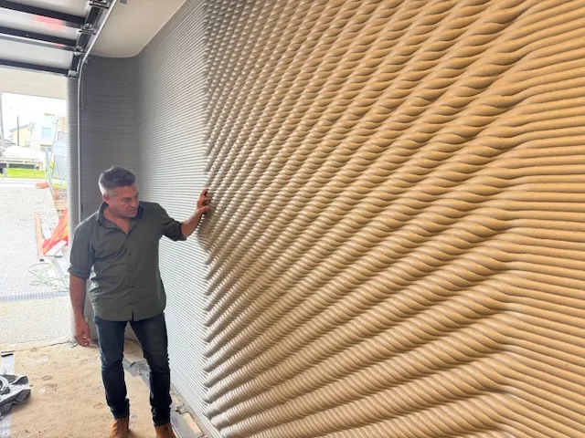 A tall, textured 3D printed architectural feature wall
